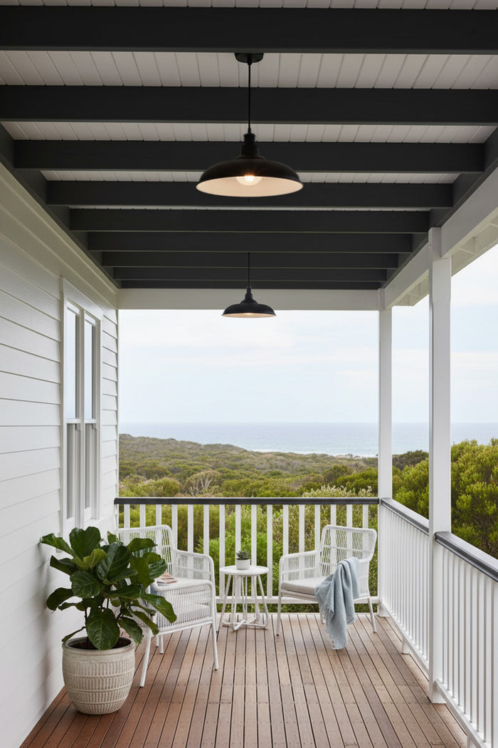 A modern porch setting with two black pendant lights hanging over a wooden deck.