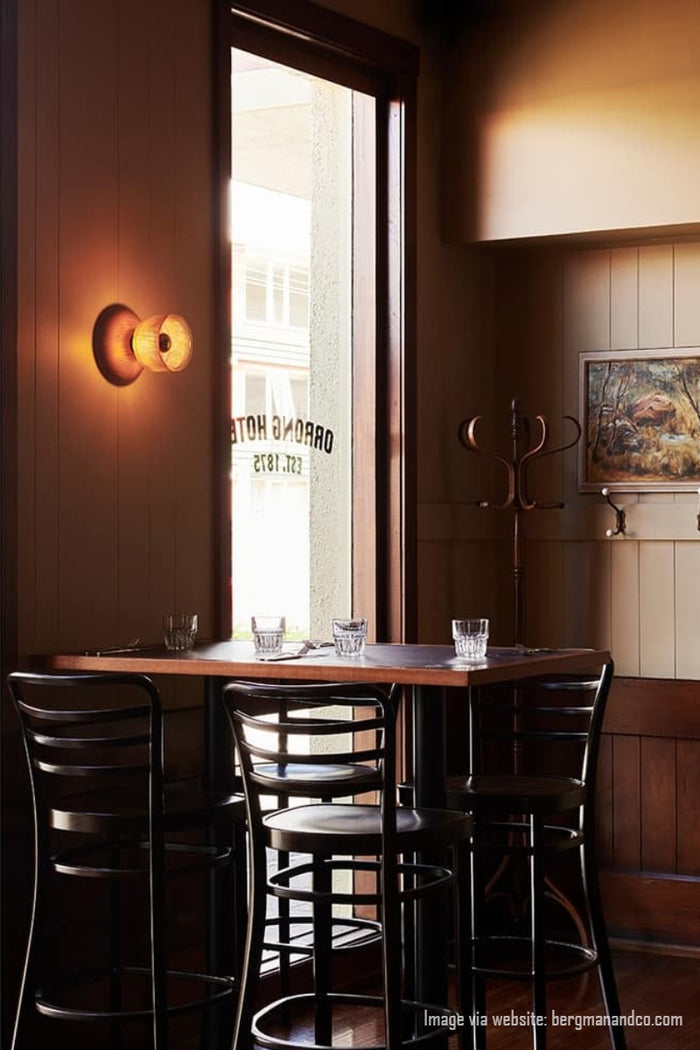 Image via website: bergmanandco.com. Orrong Pub showing a crosshatch glass wall light with wood detailing over a dining space.