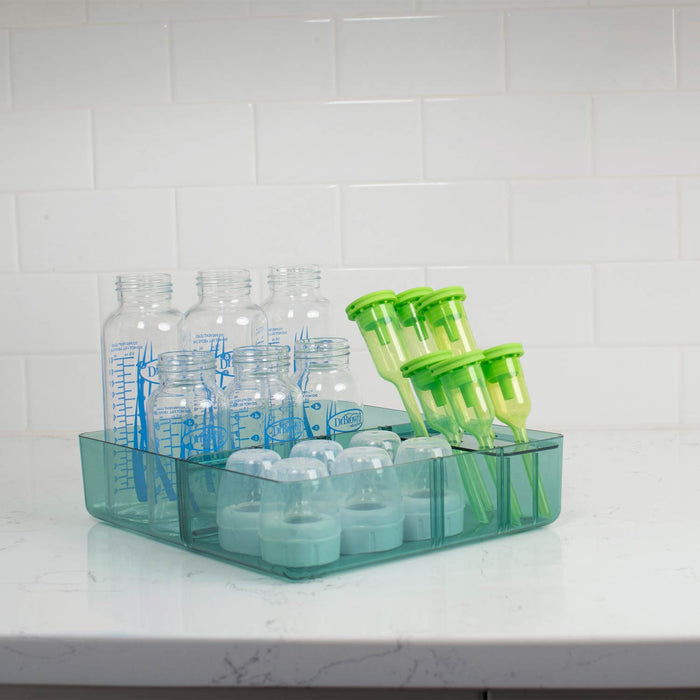 Storage tray with baby bottles and containers on a kitchen counter