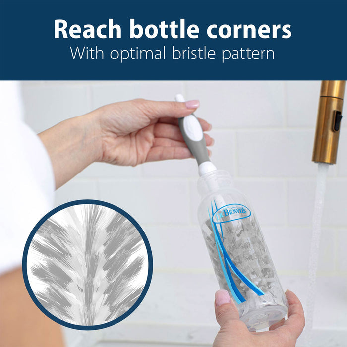 A hand uses the Dr. Brown’s™ Deluxe Bottle Brush by Dr. Brown's to clean inside clear baby bottles under running water, with a close-up highlighting the unique bristle pattern and effective cleaning action.