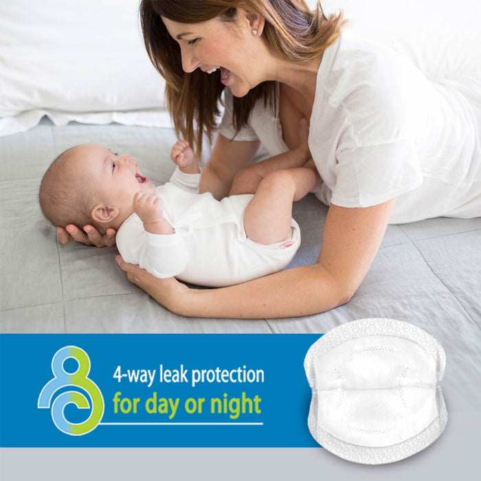 A smiling woman lies on a bed holding a laughing baby. Below them is a graphic of Dr. Brown’s™ Disposable Breast Pads with text: “4-way leak protection for day or night.”.