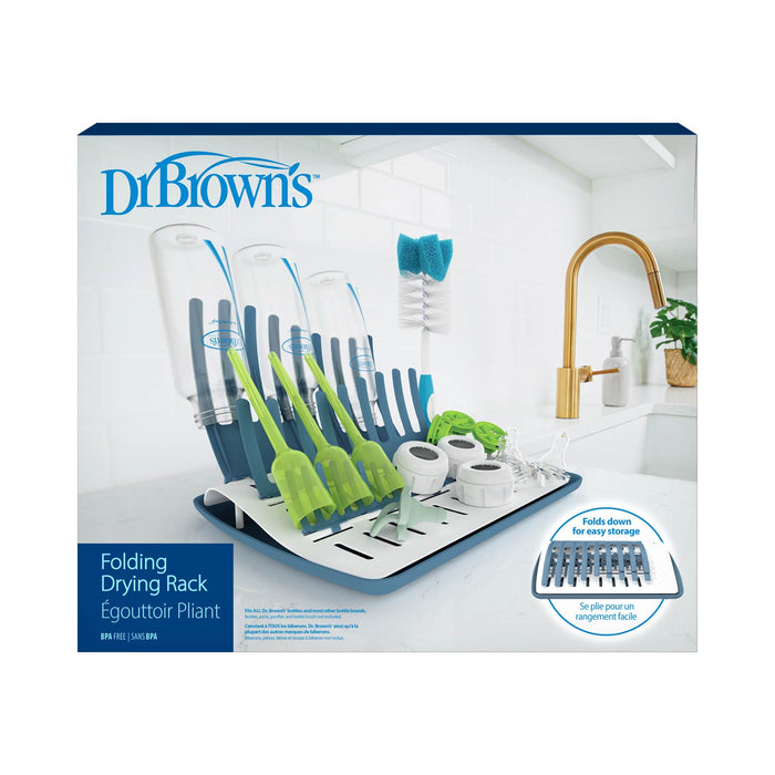 Dr. Brown's™ Folding Baby Bottle Drying Rack sits on the kitchen counter, neatly holding baby bottles, brushes, and accessories, with a sink and faucet in the background.