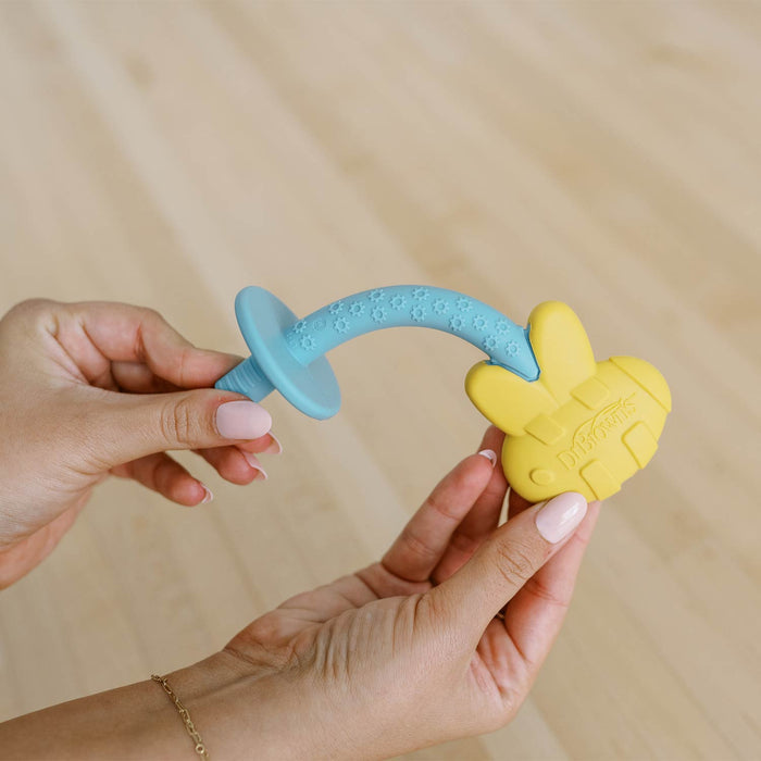 Person holding a teething tube with blue handle and yellow bee shape