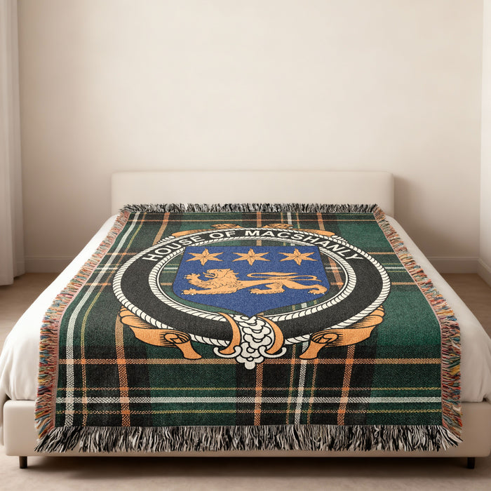 MacShanly family crest emblem woven blanket displayed on a bed