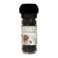 A clear glass spice jar filled with smoked black peppercorns, featuring a black grinder cap and a white label that reads 'SMOKED BLACK PEPPERCORNS' and 'ORGANIC PEPPERCORNS'.